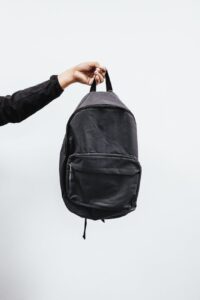 person holding black backpack